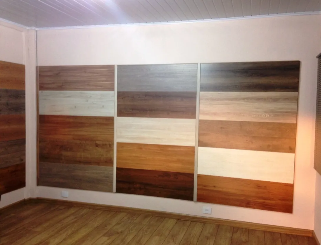 Painel com amostras de pisos laminados e vinílicos em vários tons de madeira